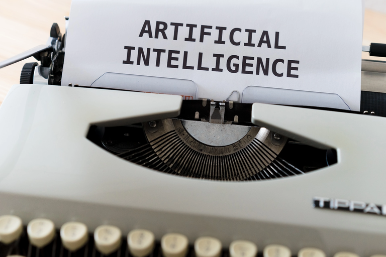 Typewriter page with the words “Artificial Intelligence”.